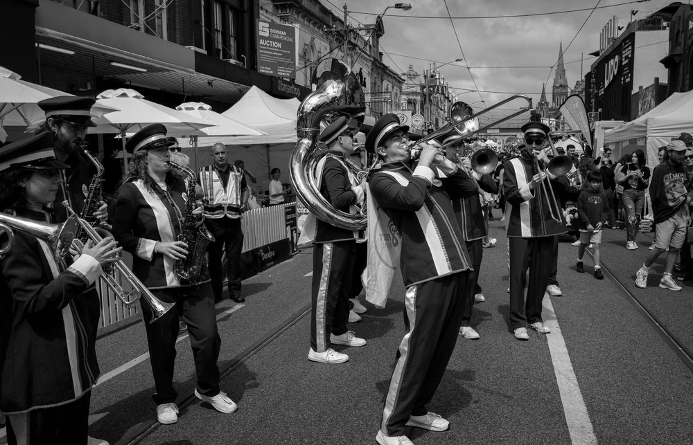 A marching band parading down Glenferrie Road, in black and white