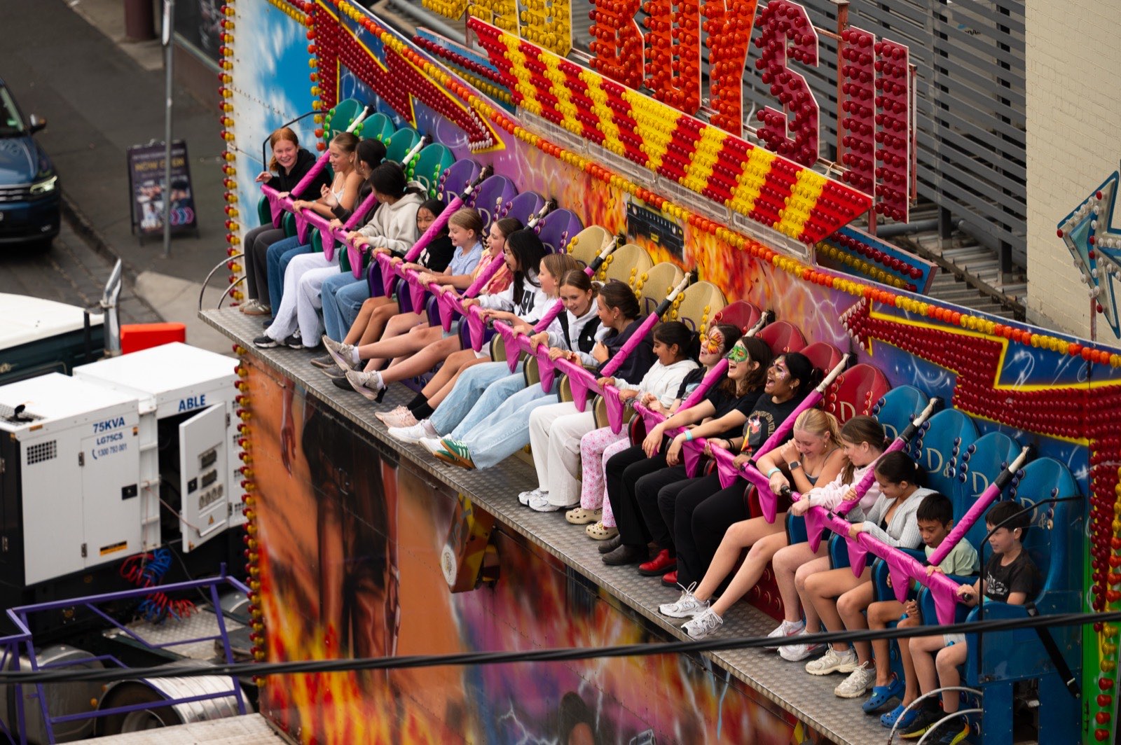 A pink carnival swing ride spinning above the strip