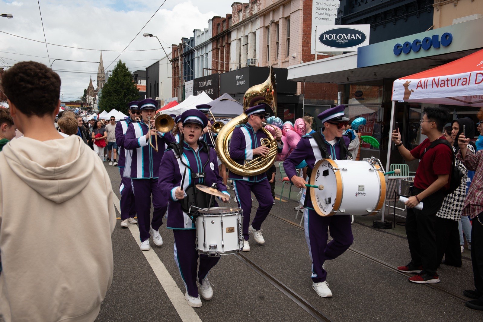 Marching band drummers performing down the street