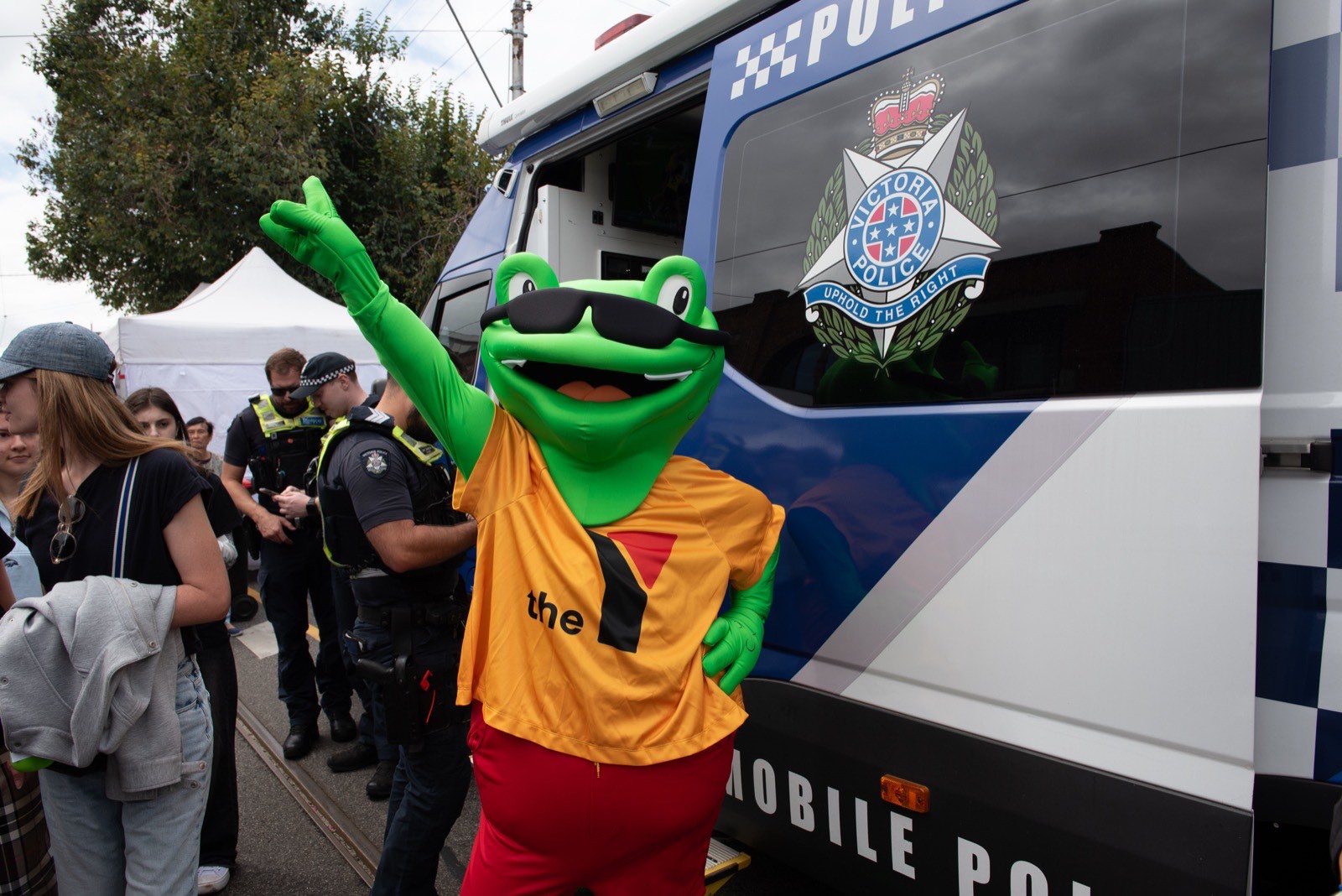A costumed frog mascot greeting festival-goers