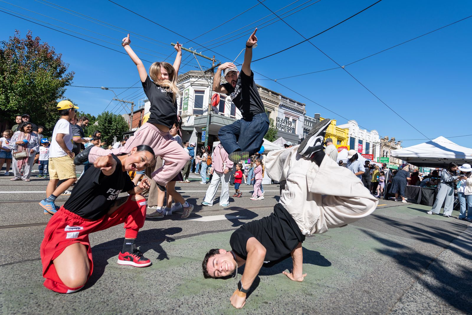 Breakdancers mid-leap during a street performance