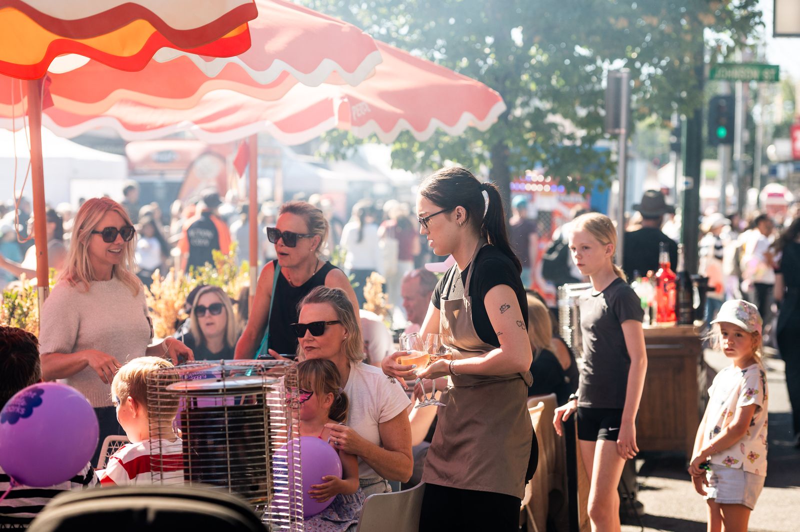 Families relaxing under striped umbrellas at the festival